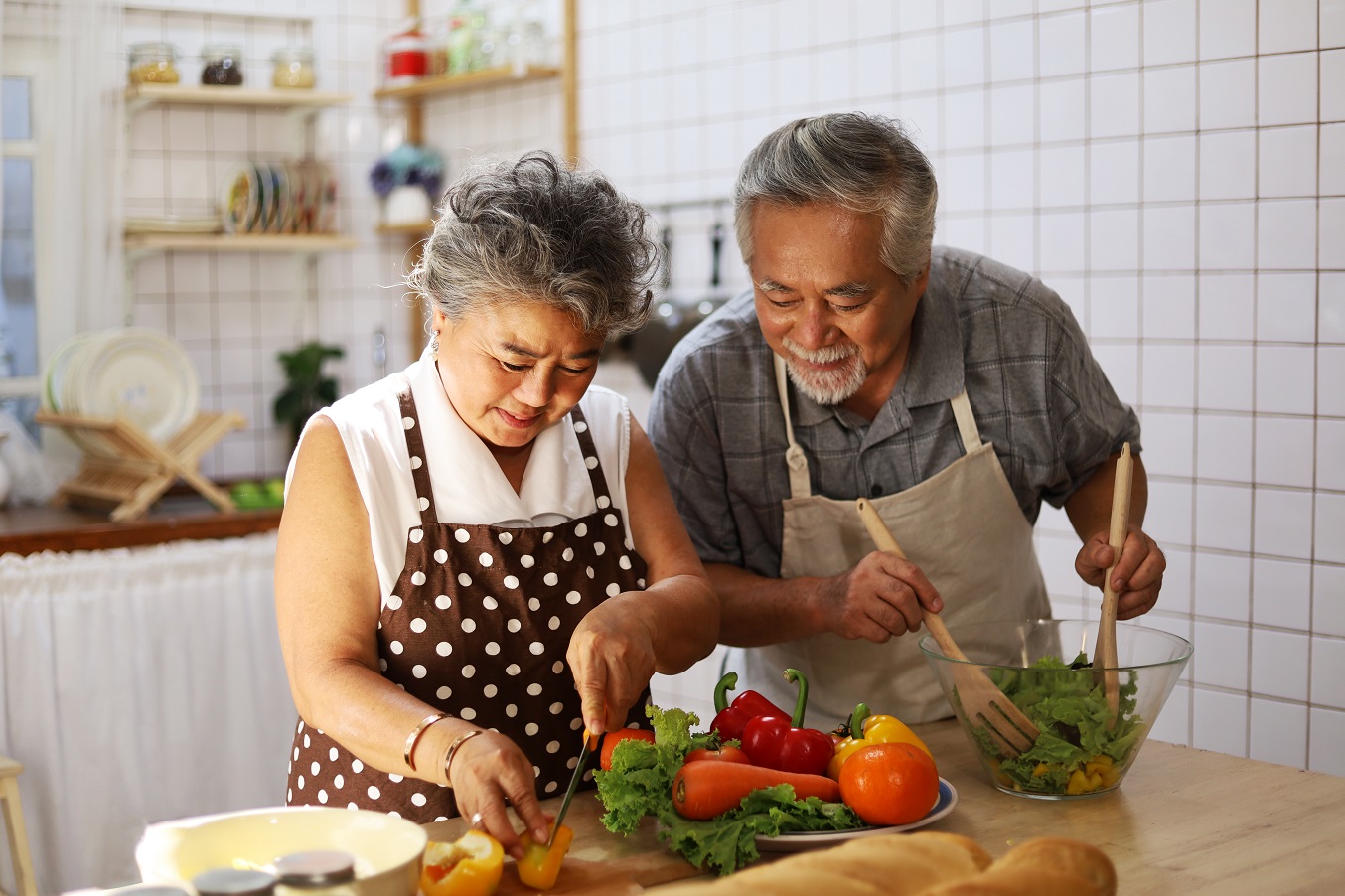 A man and woman preparing vegetables in the kitchen