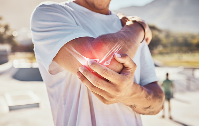 A man holds his elbow as if in pain.