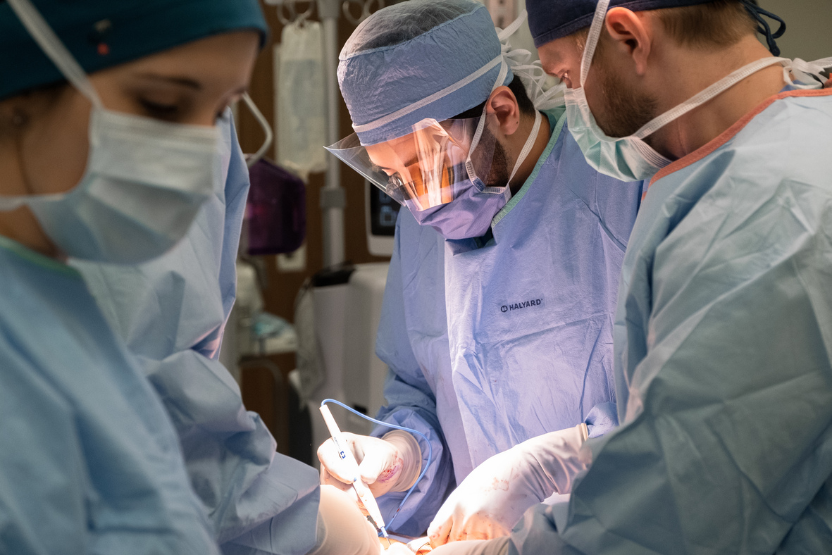 A healthcare provider and his surgical assistants performing a surgery.