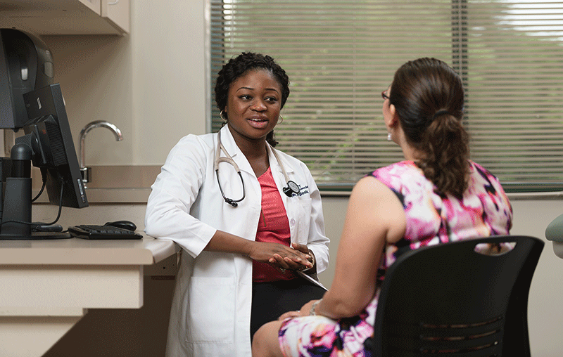 University Health’s family medicine provider, Dr. Iyunoluwa Agboola speaking with a female patient.