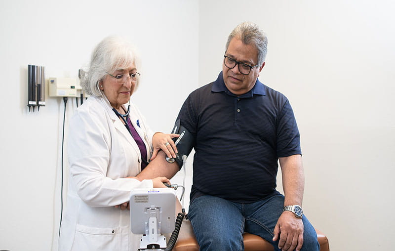 University Health FNP, Elizabeth Martinez checking patients blood pressure at the University health Edgewood Clinic in San Antonio. 